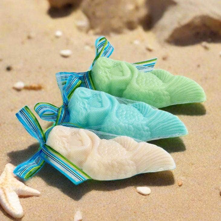 Three colorful soap bars in clear packaging on a light wooden surface