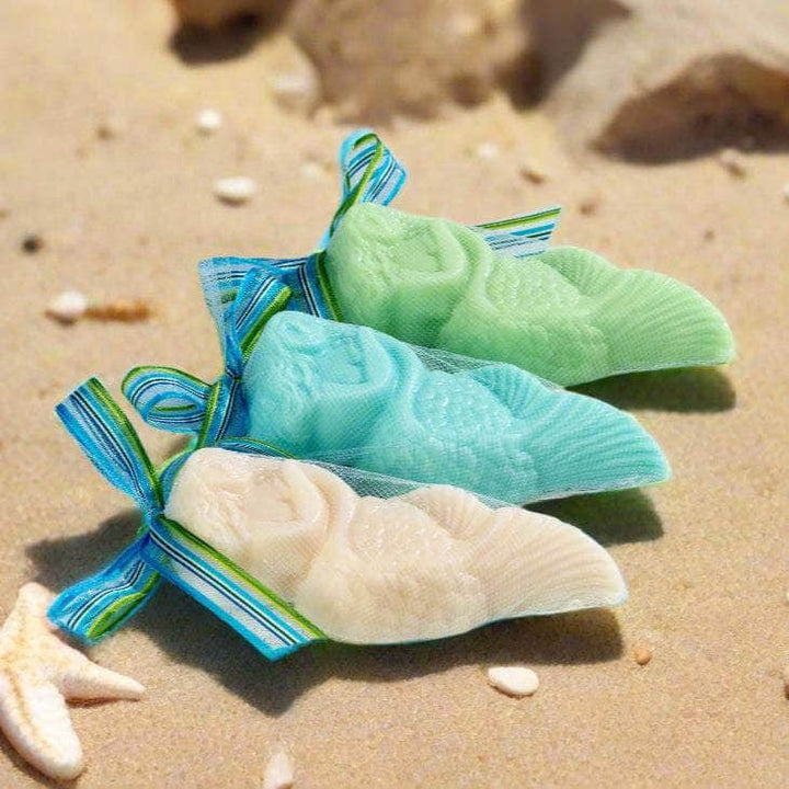 Three colorful soap bars in clear packaging on a light wooden surface